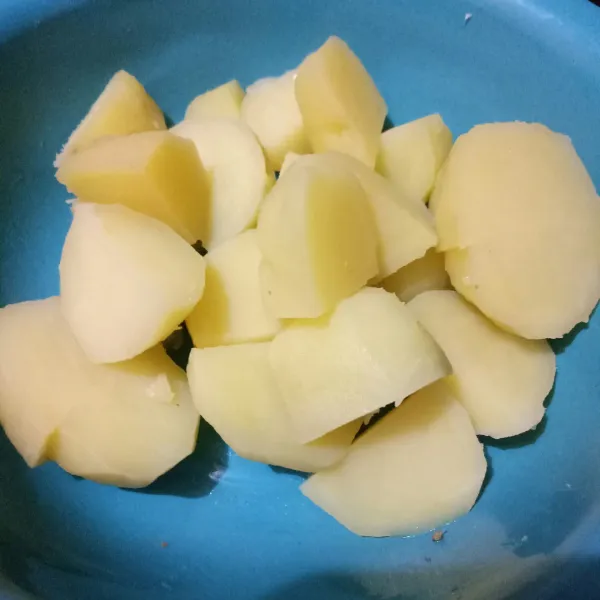 Kupas kentang lalu tiap kentang belah menjadi empat.