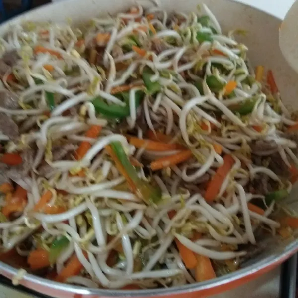 Masukkan toge, aduk rata sebentar, lalu matikan api. Beri minyak wijen. Aduk rata, sajikan.