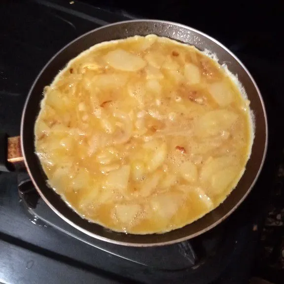 Panaskan sedikit minyak, masukkan adonan telur, masak dengan api kecil dan tutup wajannya, masak hingga matang sisi bawahnya.
