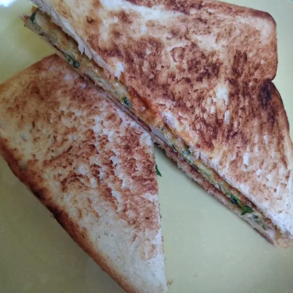 Belah roti panggang menjadi segitiga dan siap disajikan.