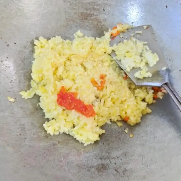 Masukkan campuran nasi putih, telur, dan penyedap rasa. Tambahkan saus gochujang dan saus sambal. Aduk hingga rata. Masak hingga matang.