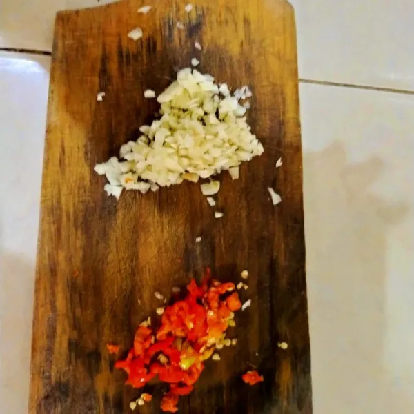 Iris tipis-tipis bawang putih dan cabe rawit.