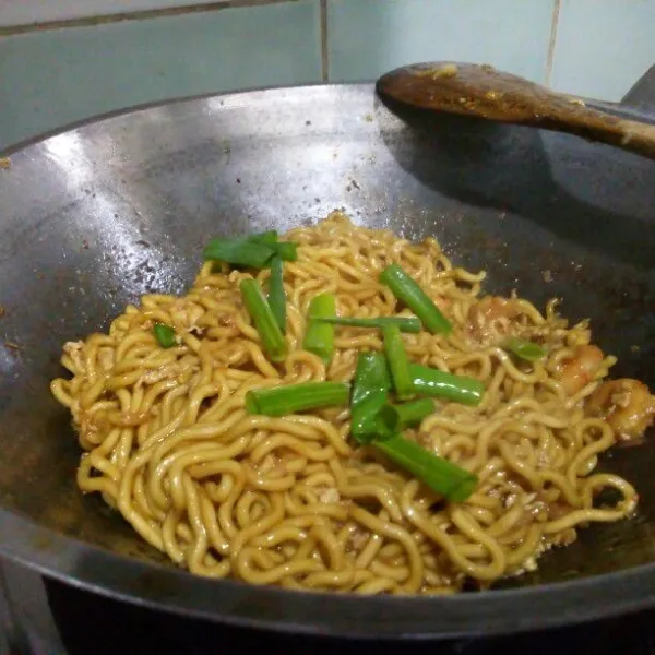Masukkan mie, aduk rata. Koreksi rasa. Terakhir masukkan minyak wijen & potongan daun kucai atau daun bawang, aduk rata. Sajikan.