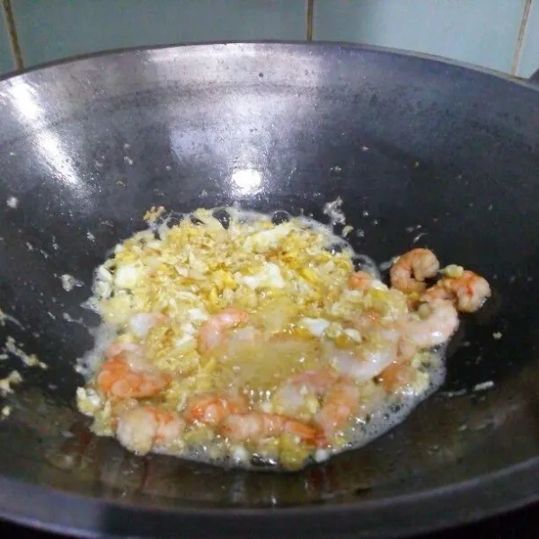 Masukkan bawang bombay, tumis sampai harum, lalu bawang putih, tumis lagi sampai harum. Masukkan udang, aduk-aduk sampai berubah warna.