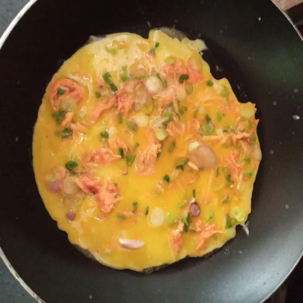 Tuangkan adonan telur di teflon tipis.