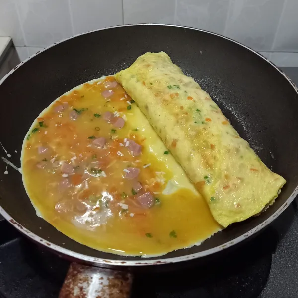Setiap kali menuang kocokan telur jangan terlalu banyak, supaya bagian dalam adonan matang.