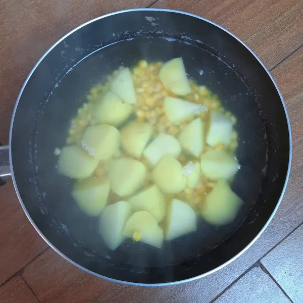 Rebus kentang hingga 3/4 matang. Masukkan jagung pipil. Rebus hingga matang. Saring.