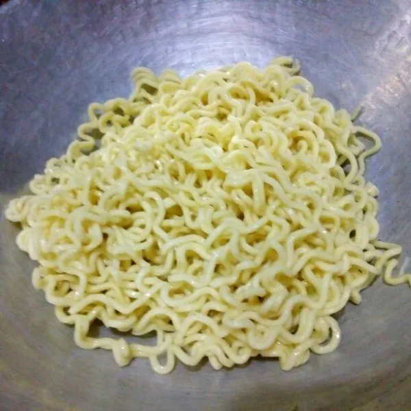 Rebus mie sampai cukup lunak, jangan terlalu lembek. Beri 1 sdm minyak goreng, campur rata, tiriskan.