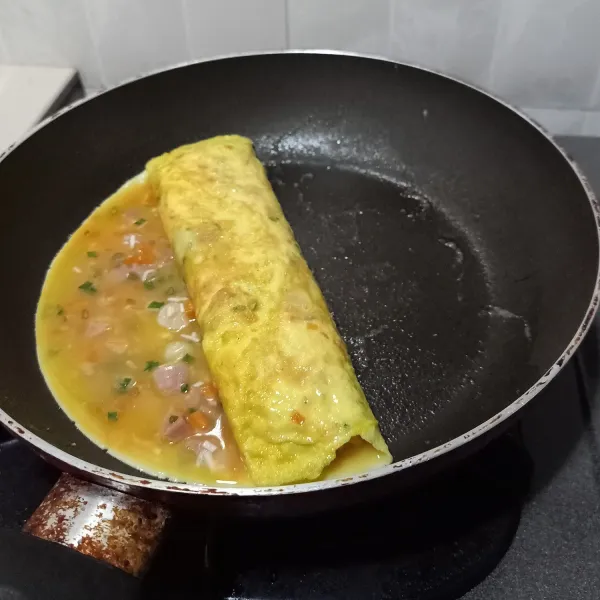 Setiap kali menggulung telur, geser pelan telur kekanan, kemudian tuang lagi disebelah kiri dengan kocokan telur, biarkan bagian bawah keras, kemudian gulung lagi, begitu seterusnya sampai adonan kocokan telur habis.