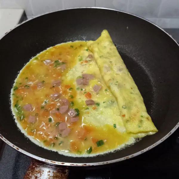 Panaskan teflon, beri sedikit minyak goreng. Kemudian tuang secukupnya kocokan telur, ratakan. Biarkan bagian bawah telur kokoh, kemudian gulung perlahan sambil digeser kebagian kanan telur, sisakan sedikit ujung telur, kemudian tuang sedikit kocokan telur lagi dan biarkan kokoh, baru digulung lagi.