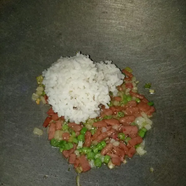 Siapkan wajan, panaskan minyak. Tumis bawang bombay sampai harum, masukkan buncis dan smoked beef. Aduk rata sampai buncis layu lalu masukkan nasi. Aduk rata.