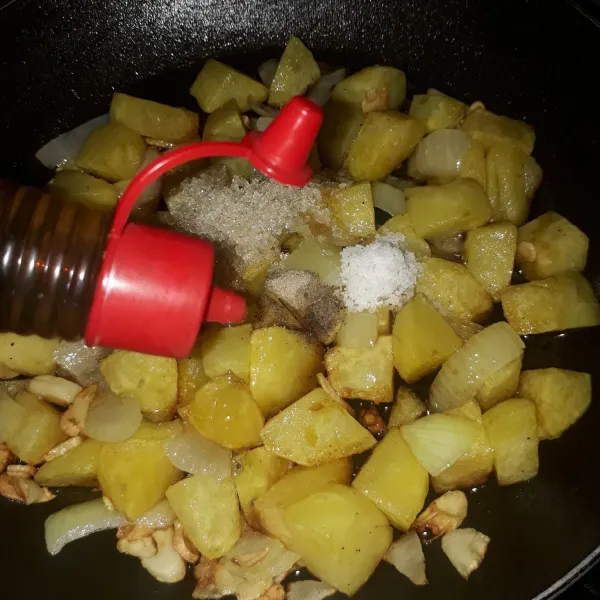 Tambahkan garam, gula, merica, kecap asin dan minyak wijen. Aduk rata sampai bumbu meresap ke dalam kentang.