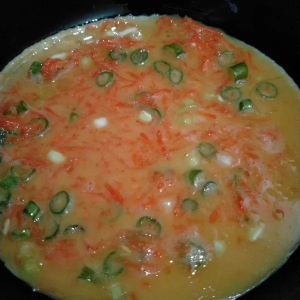 Panaskan secukupnya minyak goreng di atas teflon, tuang setengah adonan telur, gulung ke pinggir teflon.
