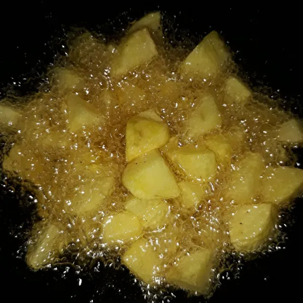 Kupas kentang, cuci bersih lalu potong dadu. Goreng kentang sampai matang.