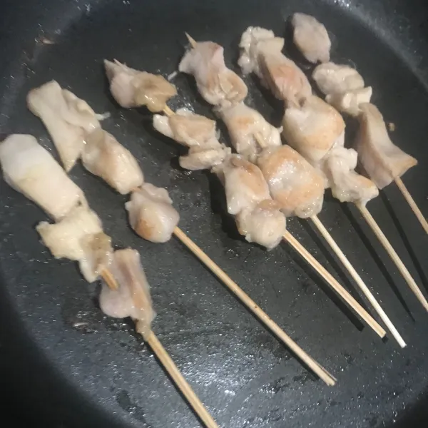 Tusuk ayam dengan tusuk sate kemudian panggang di teflon dengan api sedang hingga matang