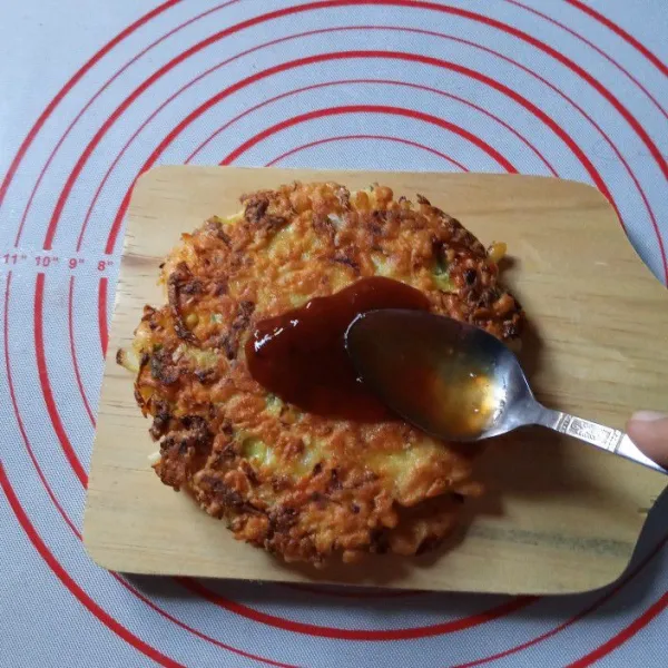 Pindahkan ke piring saji, oles permukaannya dengan saus okonomiyaki secukupnya.