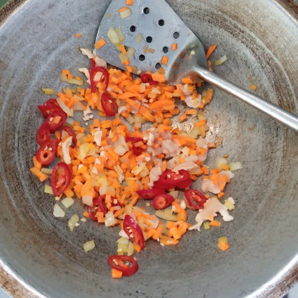 Tumis bawang bombai sampai harum dan layu. Kemudian masukkan wortel, ayam dan cabai merah. Aduk rata. Masak sampai ayam berubah warna.