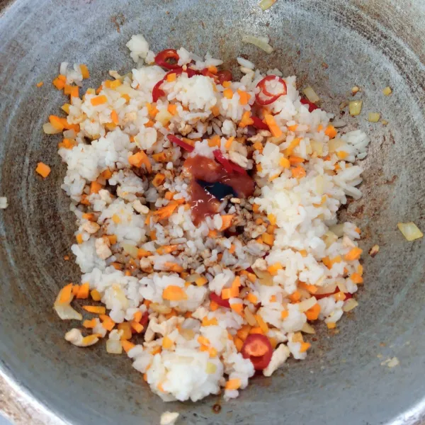 Masukkan nasi, kecap manis, saos sambal, gula, garam dan lada bubuk. Aduk rata.