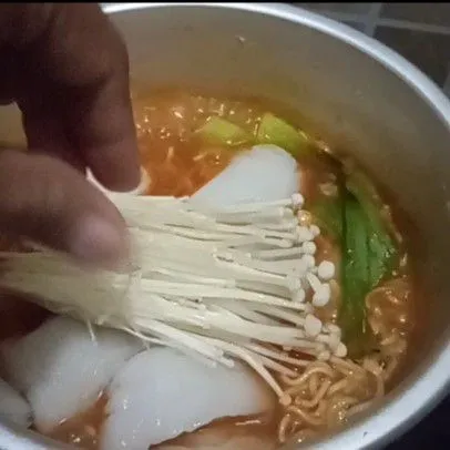 Tambahkan mie, tunggu hingga mie matang. Masukkan enoki.