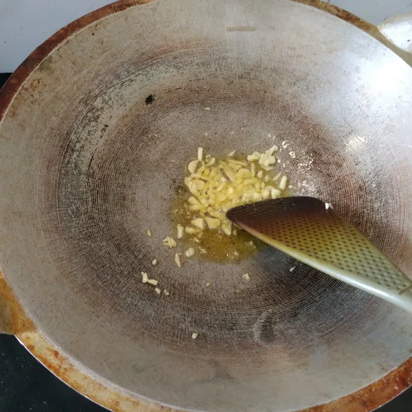 Tumis bawang putih hingga layu dan wangi. Masukkan kecap asin jepang.