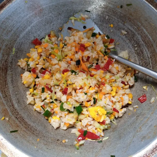 Masukkan nasi, kecap asin, minyak wijen, gula, garam dan lada bubuk. Aduk rata. Masak sampai bumbu meresap. Icip rasa. Sajikan.