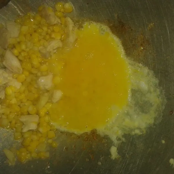 Sisihkan tumisan agak ke tepi wajan lalu masukan kocokan telur. Aduk-aduk sampai telur berubah menjadi gumpalan-gumpalan kecil.