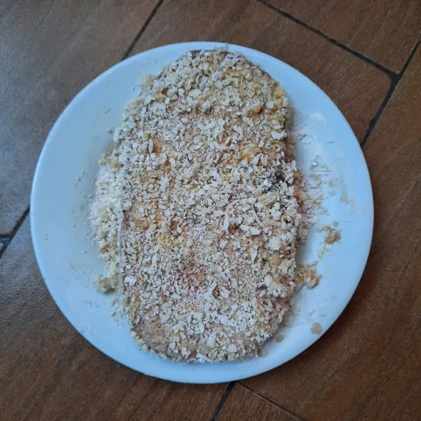 Lumuri daging dengan tepung terigu. Celup ke kocokan telur. Gulingkan ke tepung roti.
