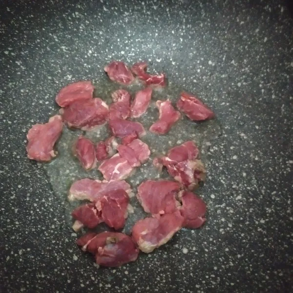 Panaskan minyak, lalu masukkan irisan daging, beri garam dan merica, aduk dan masak selama 5 menit.