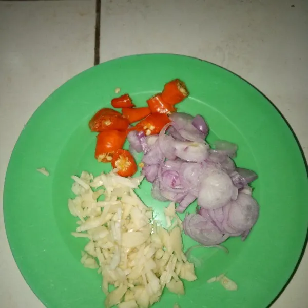 Iris tipis-tipis bawang putih, bawang merah, dan cabe rawit.