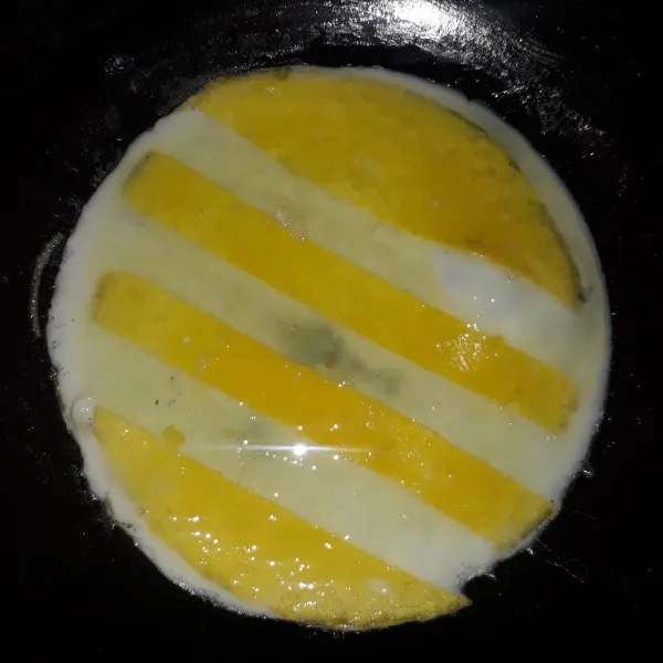 Masukkan putih telur di atas kuning telur. Masak sampai matang.