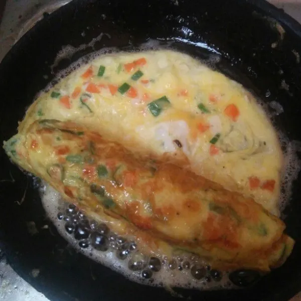 Setelah  terlihat telur. Matang gulung sebagian telur dengan bantuan sendok, lalu tuang kembali secukupnya adonan telurnya, sambungkan ke telur yang sebelumnya.