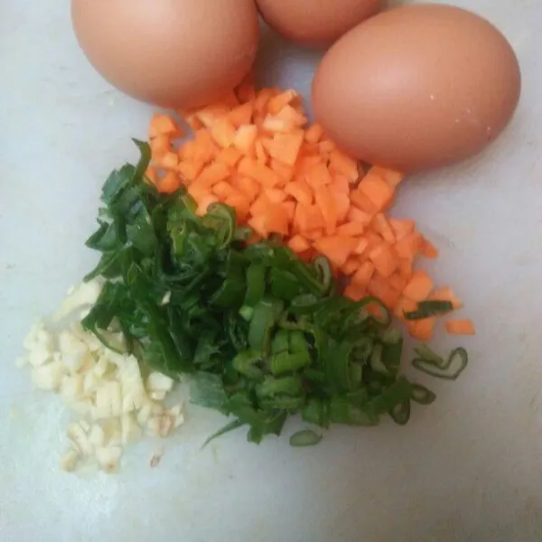 Cincang halus bawang putih,  potong dadu kecil-kecil wortel, iris tipis daun bawang .