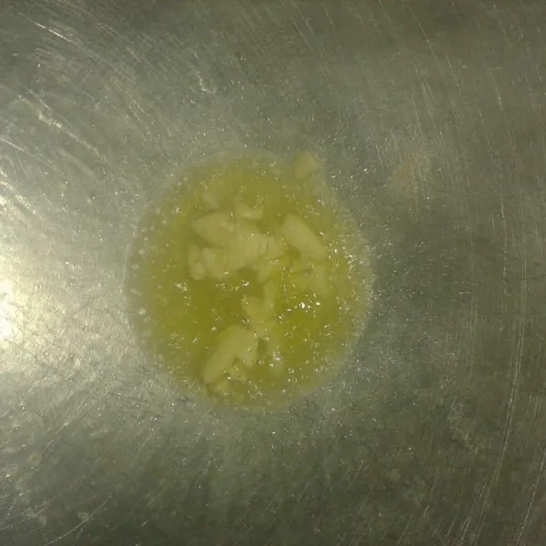 Panaskan minyak, lalu tumis bawang putih sampai harum.