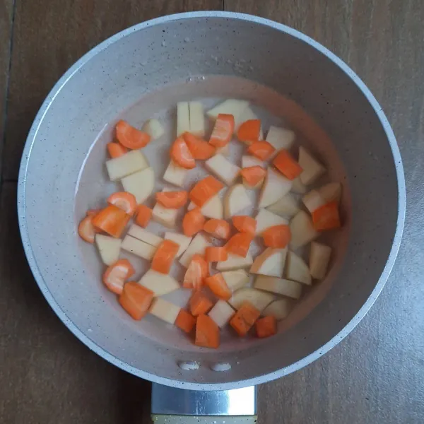 Membuat saus kari: rebus kentang (dipotong kotak) dan wortel (dipotong kotak) bersama 350 ml air hingga mendidih. Masukan bumbu kari instan. Masak hingga kentang dan wortel matang.