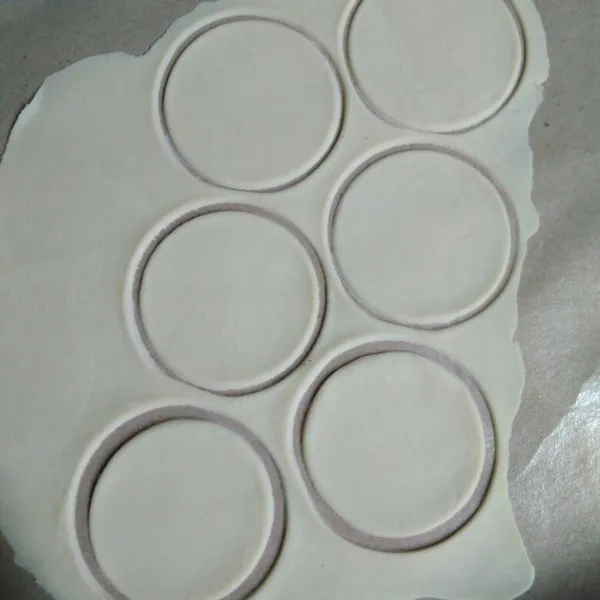 Tipiskan adonan menggunakan rolling pin atau pasta maker, kemudian cetak dengan mulut gelas. Sisihkan (tabur kulit dengan tepung terigu agar tidak menempel).
