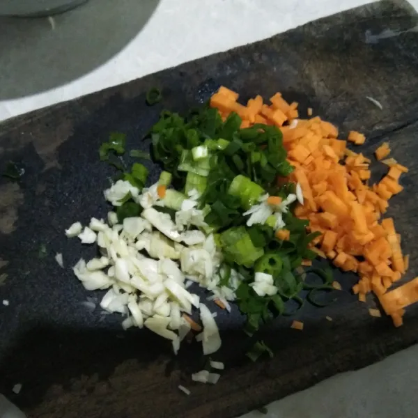 Cincang halus wortel, bawang putih, dan daun bawang.