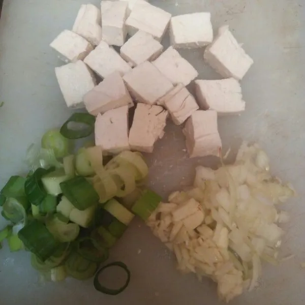 Siapkan semua bahan, potong dadu tahu, cincang bawang bombay, bawang putih dan daun bawang.