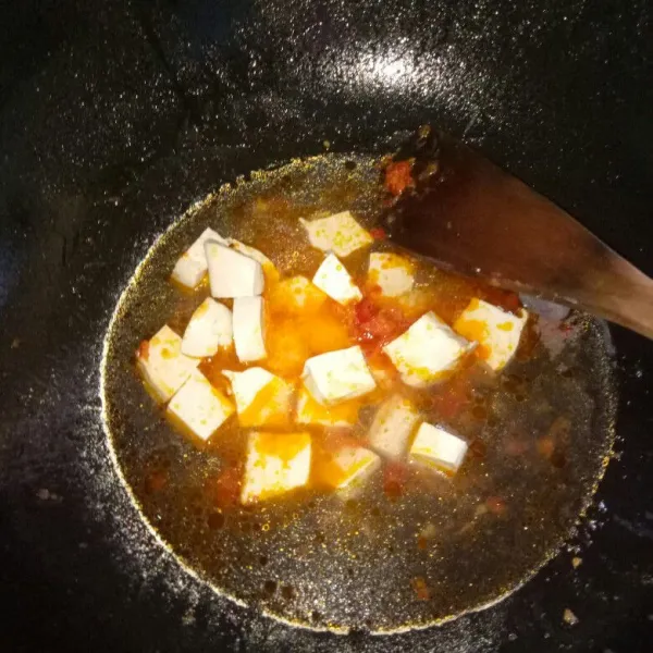 Siapkan pan, panaskan minyak. Tumis bumbu halus sampai harum, masukkan tahu lalu aduk rata. Tambahkan air, masak sampai mendidih.