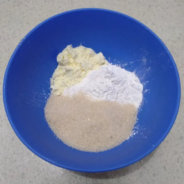 Masukkan 125 gram tepung ketan putih, 80 gram gula pasir, dan 1 sdm susu bubuk putih ke dalam mangkuk.