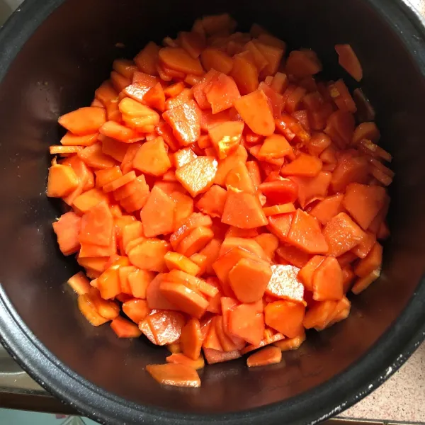 Masukkan potongan buah pepaya yang sudah dipotong kecil-kecil ke dalam wadah rebus