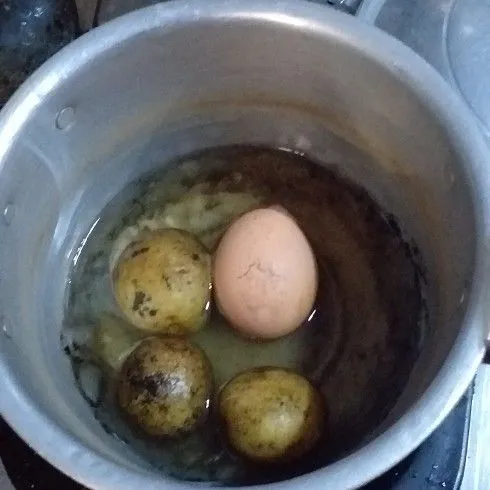 Rebus telur dan kentang hingga matang, dinginkan dengan air dingin.