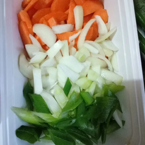 Siapkan wortel, daun bawang dan bawang bombai dipotong serong.