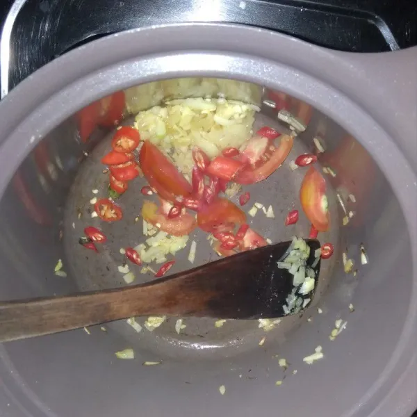 Tumis bawang putih, bawang bombai, sampai layu. Lalu masukkan cabe dan tomat tumis sampai harum.