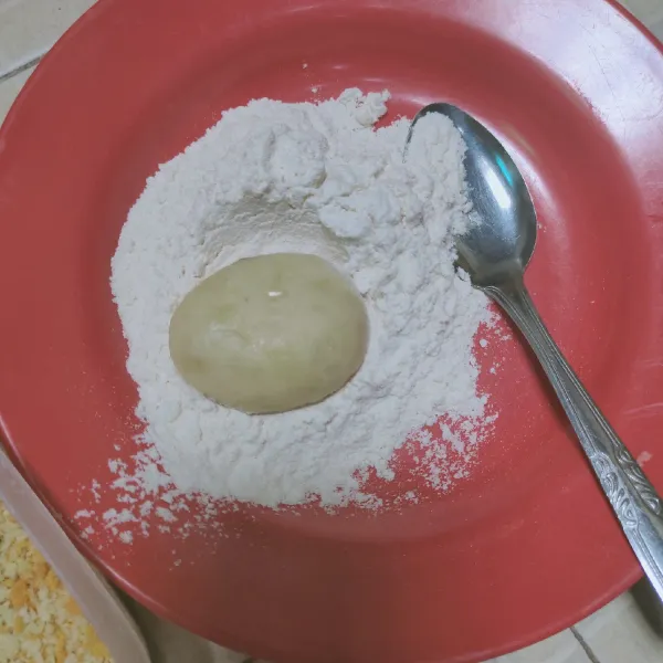 Tuangkan tepung terigu dalam wadah, kemudian gulingkan kentang di atas tepung, balur secara merata.