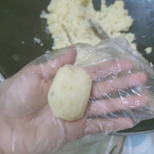Selagi hangat, tumbuk kentang hingga halus, kemudian ambil 1 sdm kentang, lalu bentuk pipih lonjong.
