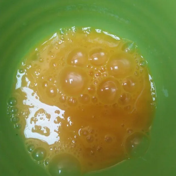 Pecahkan telur sisihkan 1 bagian putih telurnya, lalu kocok lepas.