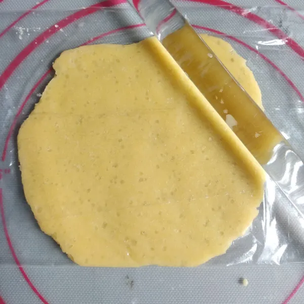Keluarkan topping dari dalam kulkas, bagi menjadi 10 bagian, kemudian tipiskan satu bagian adonan topping.