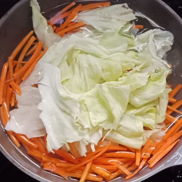 Didihkan air masukan wortel dan kol rebus hingga layu.