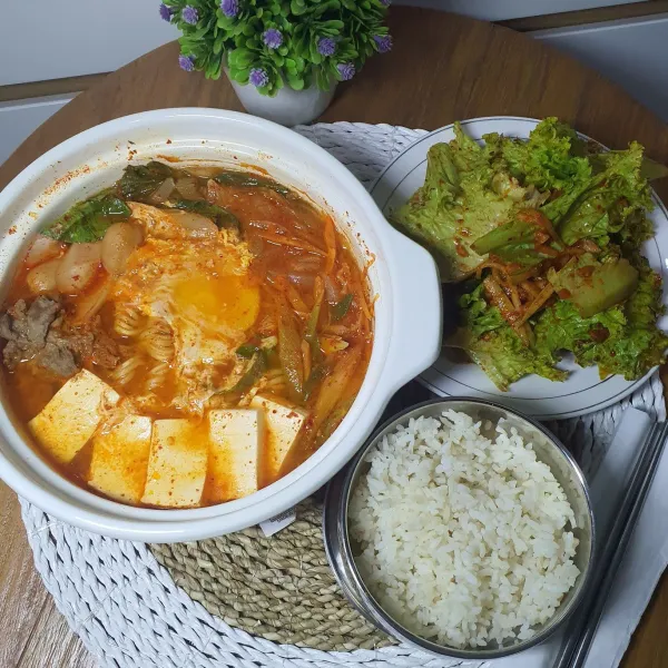 Sajikan Budae Jjigae kearifan lokal dengan nasi dan sangchu geotjeori.