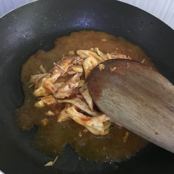 Masukkan daging ayam yang telah dipotong kecil dan kuah kimchi dan kecap asin, masak dengan api kecil hingga ayam empuk.